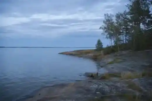 Rocky Baltic shoreline beneath a pale evening sky